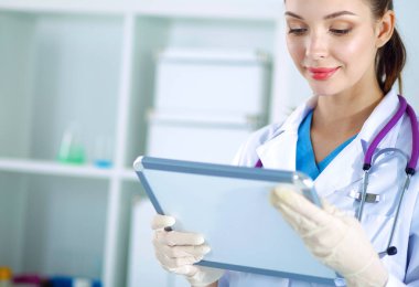 Kadın doktor hastanede dosyayla bekliyor.