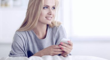 Genç ve güzel bir kadın odasında kanepede oturuyor.