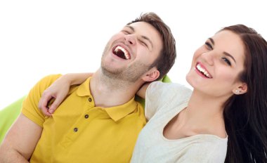 Genç, sevimli bir çift yerde yatıyor, beyaz arka planda soyutlanmış.