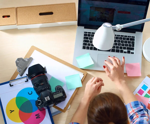 Vrouwelijke fotograaf zittend op het bureau met laptop — Stockfoto