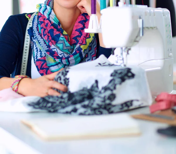 Mladá žena šití při sezení na svém pracovišti — Stock fotografie