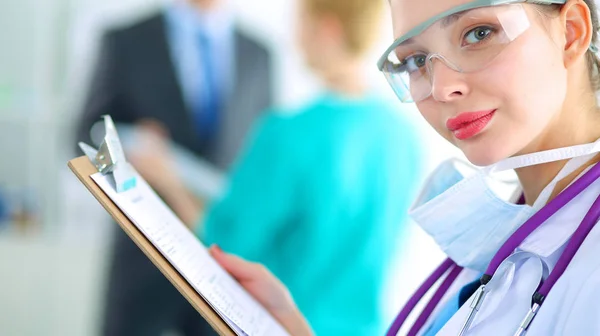 Woman doctor standing with folder at hospital — Stock Photo, Image