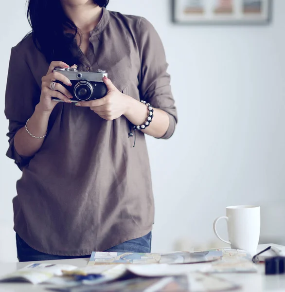 Woman sitting on a sofa in her house with camera — Stock Photo, Image