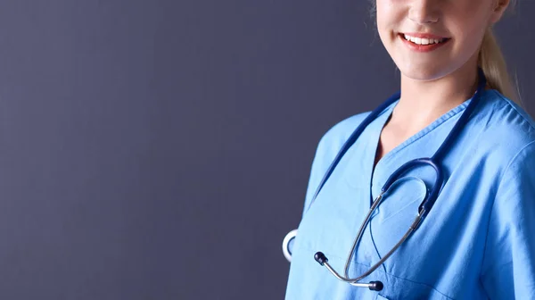 Jeune médecin femme avec stéthoscope isolé sur fond gris — Photo