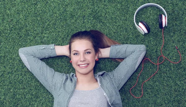 Relaxed woman  lying on the grass near headset — Stock Photo, Image