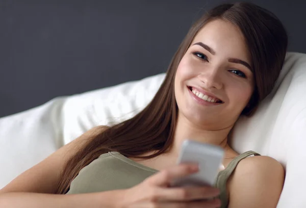 Pretty woman in her living room lying on the couch sending mess — Stock Photo, Image