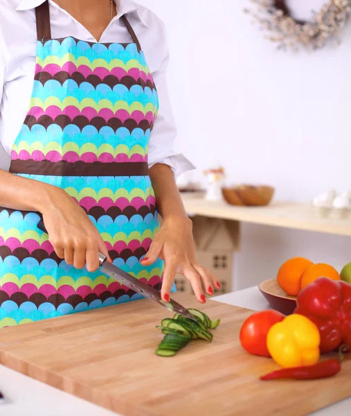 Jonge vrouw snijden groenten in de keuken — Stockfoto