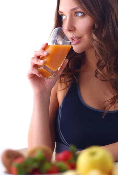 Chica sentada en la cocina en el escritorio con frutas y vasos con jugo —  Fotos de Stock