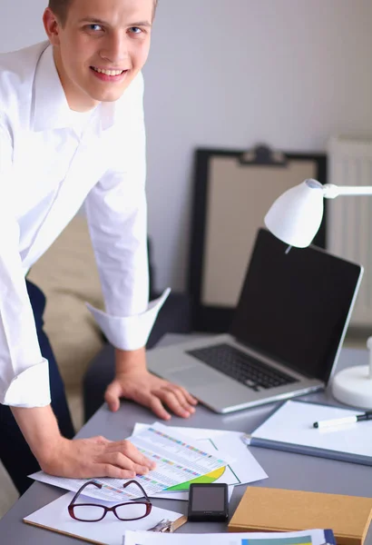 Young businessman working in office, standing near desk — Stock Photo, Image