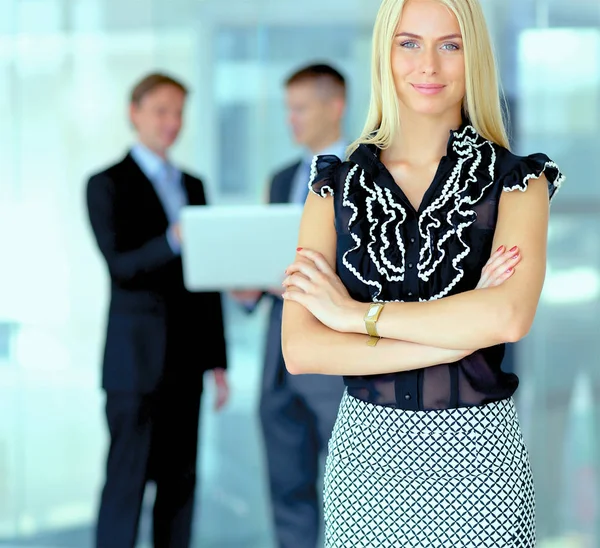 Business woman standing in foreground in office — Stock Photo, Image