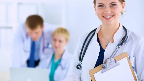 Médico feminino atraente com pasta na frente do grupo médico — Fotografia de Stock