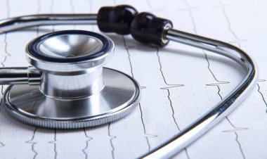 Masada yatan elektrokardiyogramda stetoskop.