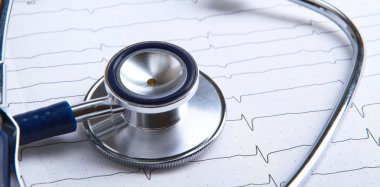 Masada yatan elektrokardiyogramda stetoskop.