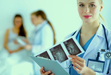 Kadın doktor hastanede steteskopla dikiliyor.