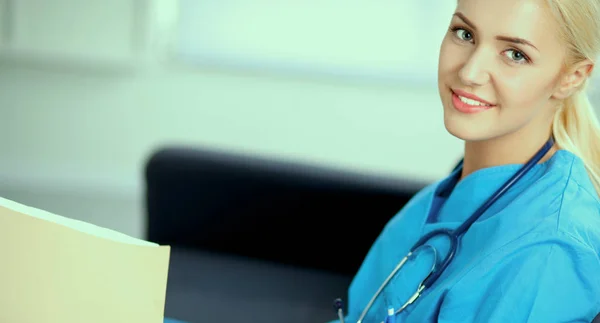 Portret szczęśliwego młodego lekarza siedzącego na kanapie z folderem — Zdjęcie stockowe
