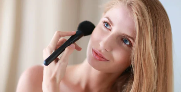 Pretty woman applying make up with brush — Stock Photo, Image