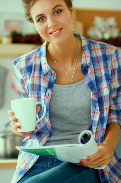 Mujer leyendo revista En la cocina en casa — Foto de Stock