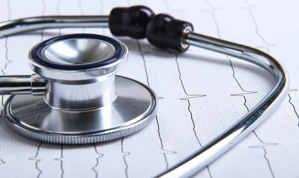 Masada yatan elektrokardiyogramda stetoskop.