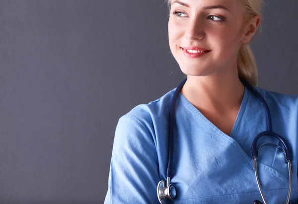 Ung läkare kvinna med stetoskop isolerad på grå bakgrund — Stockfoto