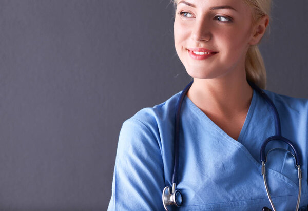 Young doctor woman with stethoscope isolated on gray background