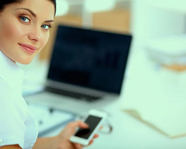 Femme d'affaires envoyer un message avec smartphone assis dans le bureau — Photo