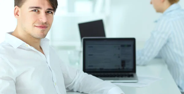 Young businessman working in office, sitting at desk — Stock Photo, Image