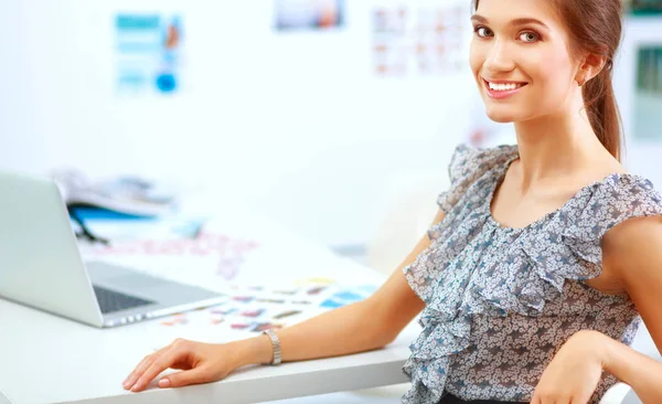 Attraktive Geschäftsfrau sitzt auf Schreibtisch im Büro — Stockfoto