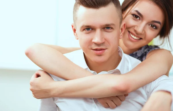 Feliz jovem casal sentado juntos no sofá — Fotografia de Stock