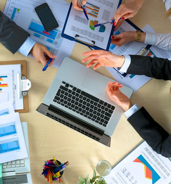 İş adamları el sıkışır, masada otururlar.