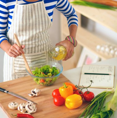 Genç kadın taze salata hazırlıyor.
