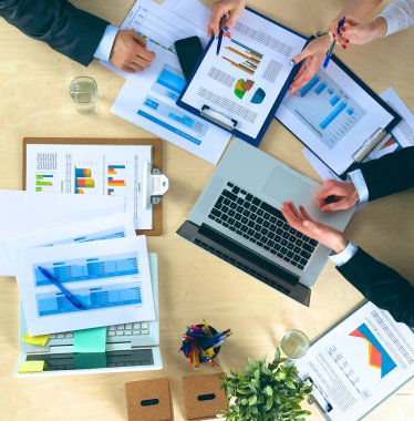 İş adamları iş toplantısında, ofiste oturup tartışıyorlar.