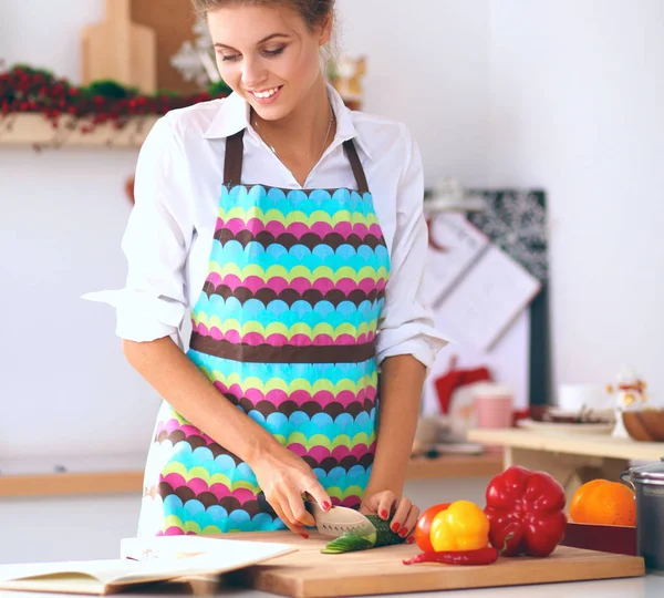 Jonge mooie vrouw snijden groenten in de keuken — Stockfoto