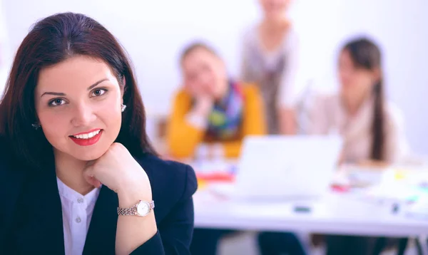 Attraente donna d'affari seduta sulla scrivania in ufficio con una tazza di caffè — Foto Stock