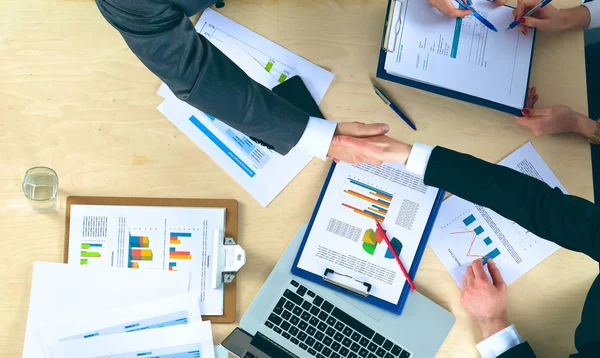 Zakenmensen handdruk, zitten aan de tafel — Stockfoto