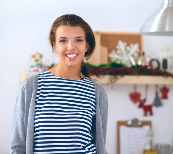 Mujer joven de pie en su cocina cerca del escritorio — Foto de Stock