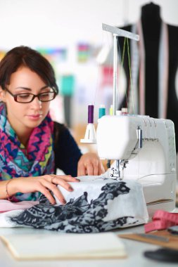 Çalışırken dikiş diken genç bir kadın.