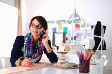 Genç terzi kâğıt üzerinde kıyafet deseni tasarlıyor.