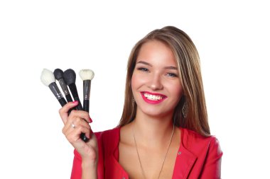 Genç güzel kadın elinde makyaj için fırça tutar