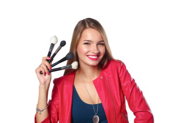 Genç güzel kadın elinde makyaj için fırça tutar