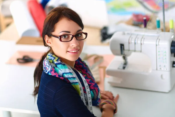 Beautiful fashion designer sitting at the desk in studio — Stock Photo, Image