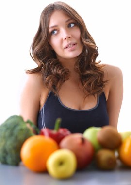 Mutfakta masada meyve suyu ve bardakla oturan bir kız.