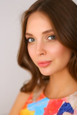 Beyaz arka planda poz veren güzel bir kadın.