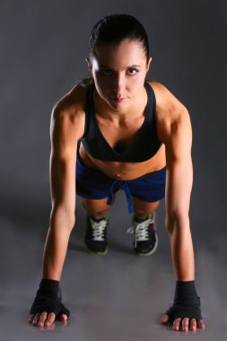 Paspasın üzerinde şınav çeken genç bir kadın.