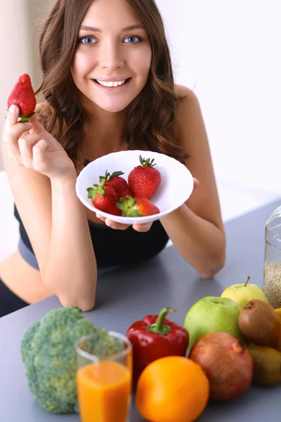 Smiling woman eating strawberry. Close up female face portrait