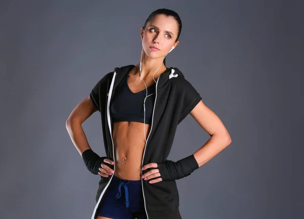 肌肉构成的运动服在黑色背景下的年轻女子 — 图库照片