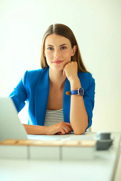 Femme assise sur le bureau avec ordinateur portable — Photo