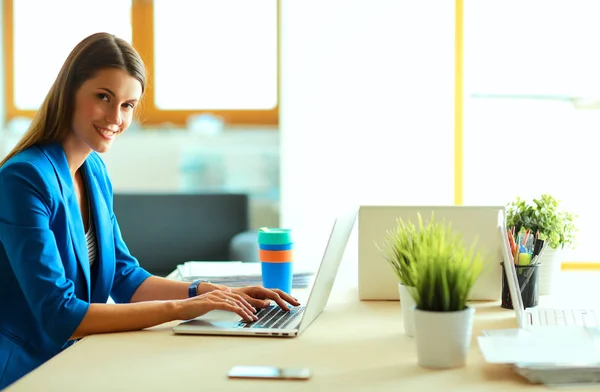 Žena sedící na stole s laptopem — Stock fotografie