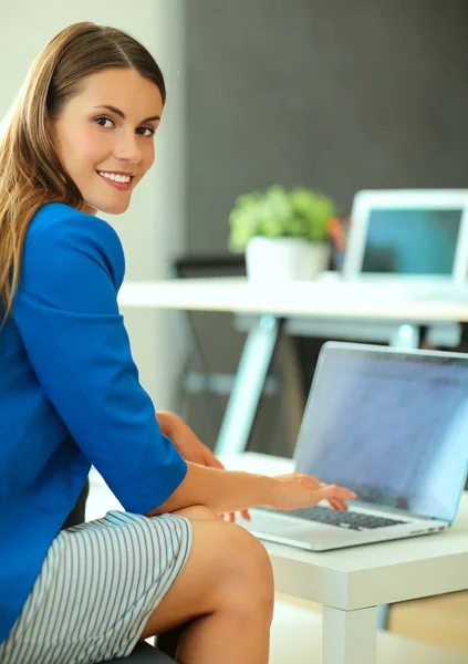 Mulher sentada na mesa com laptop — Fotografia de Stock