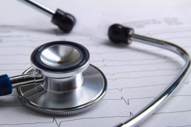 Masada yatan elektrokardiyogramda stetoskop.