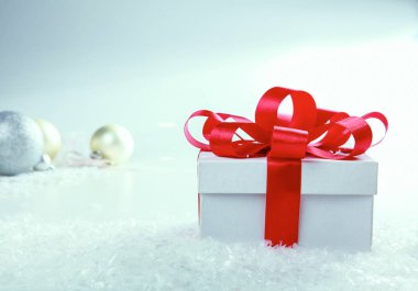 Kırmızı kurdeleli beyaz hediye kutusu.